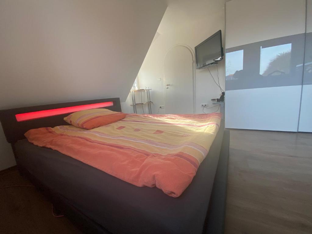 1 dormitorio con 1 cama y TV en la pared en Ferienwohnung Ipsheim Zentral, en Ipsheim