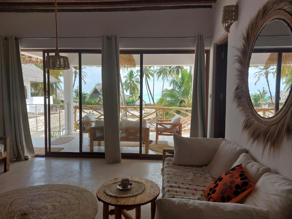 a living room with a couch and a table at Moyo House in Jambiani