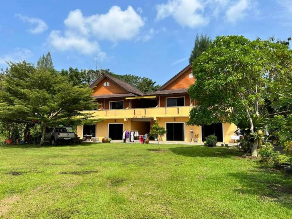 uma casa com um quintal em frente em Relaxation guesthouse em Thalang
