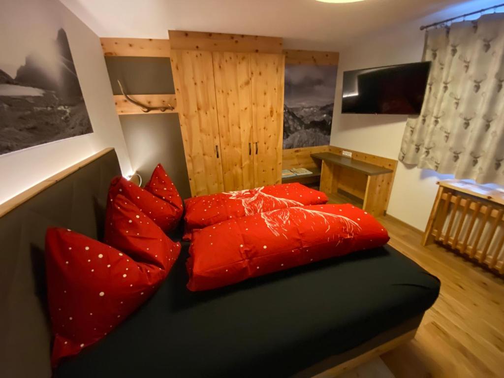 a bedroom with red pillows on a bed at Chalet Tauernbär in Großkirchheim