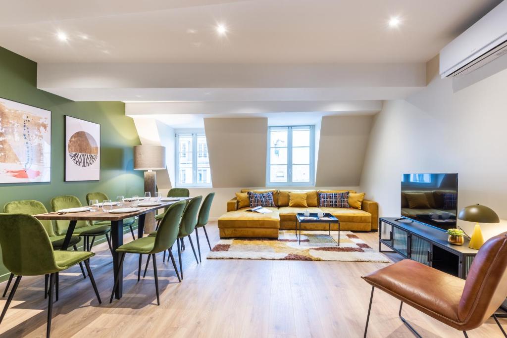 ein Wohnzimmer mit einem gelben Sofa, einem Tisch und Stühlen in der Unterkunft Sweet Inn - Bastille in Paris