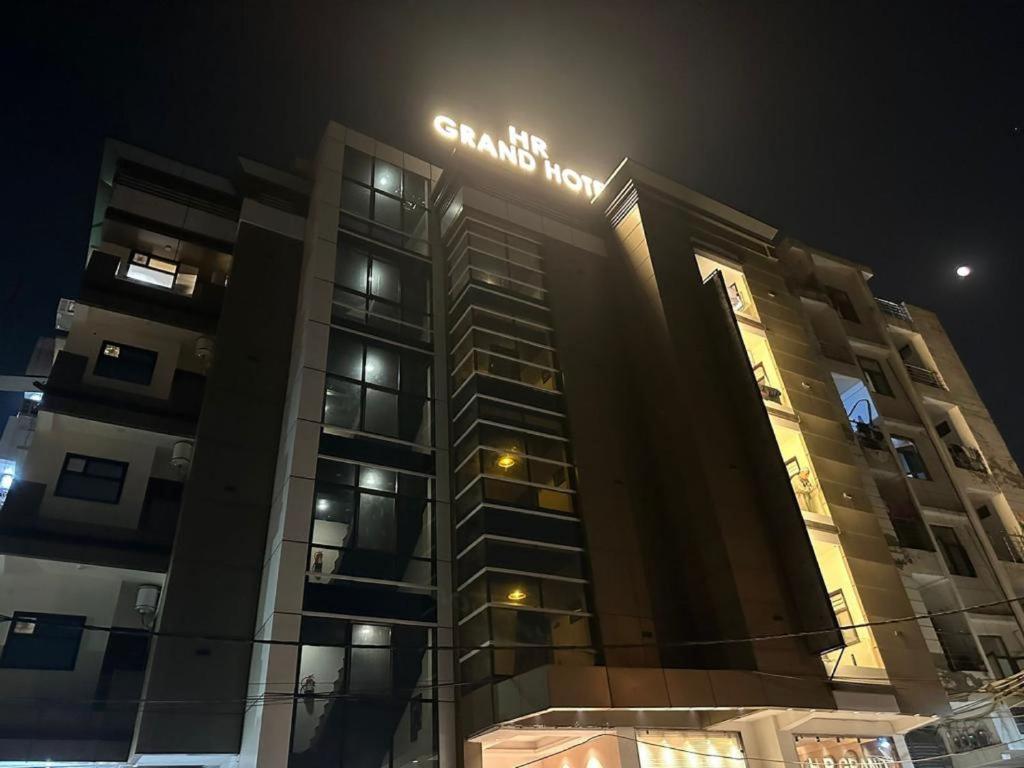 a building with a sign on it at night at HR Grand Hotel in New Delhi