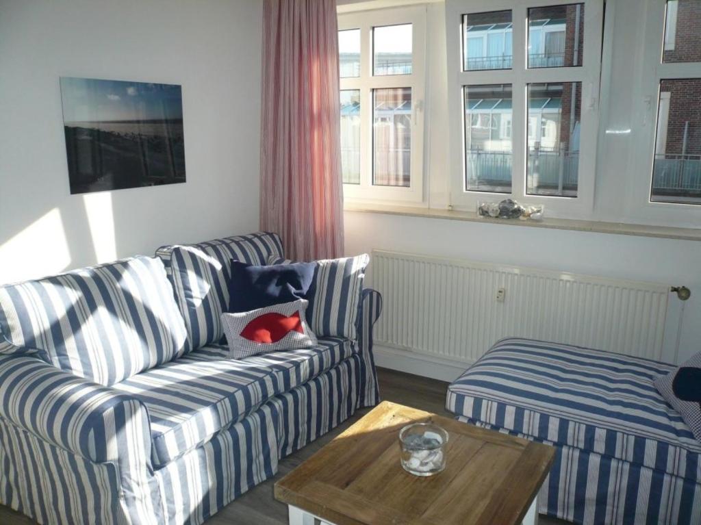 a living room with a couch and a coffee table at Ferienwohnung 206 Juist Strandburg für 5 Personen mit Schwimmbad und Sauna in Juist