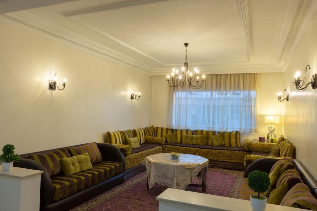 a living room with couches and a table at Grand appartement calme et lumineux + Parking GRATUIT in Casablanca