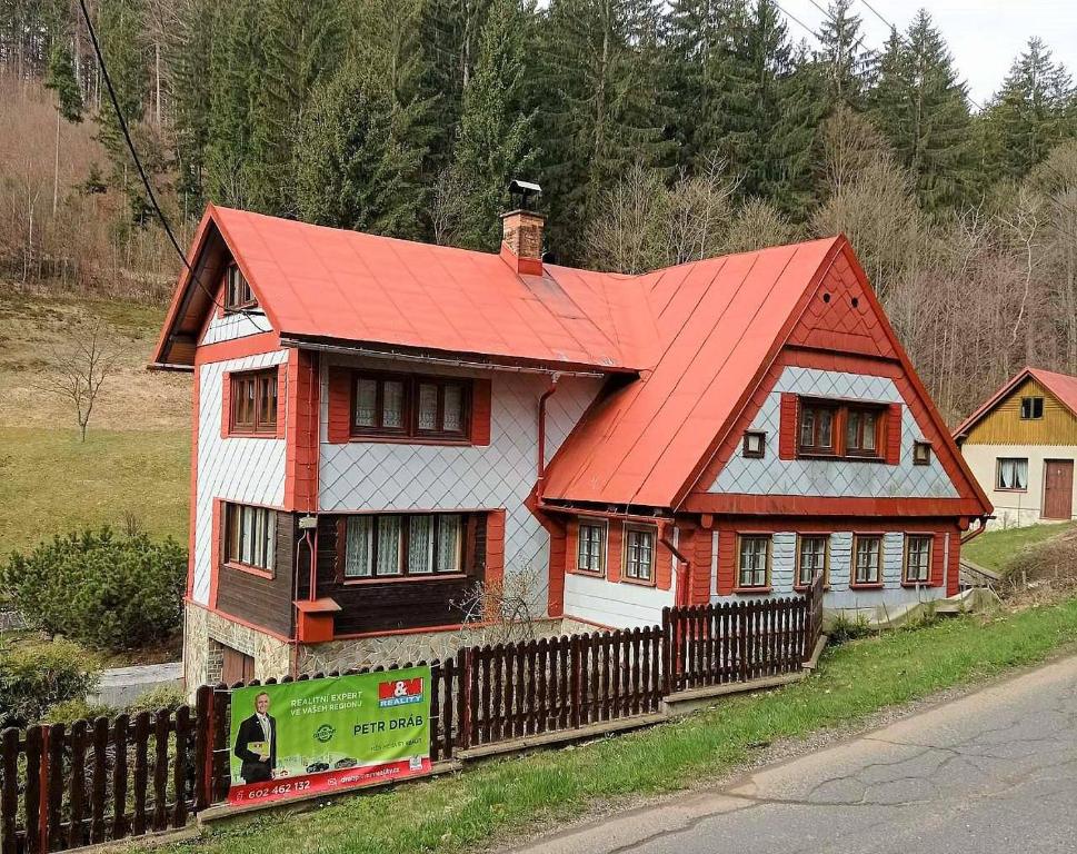 ein Haus mit einem orangenen Dach an der Seite einer Straße in der Unterkunft Ubytování v retro chalupě Na Věčnosti in Tanvald