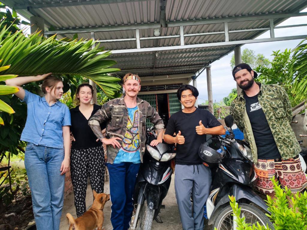 a group of people standing next to a motorcycle at Bà Ngoại Homestay in Cà Mau