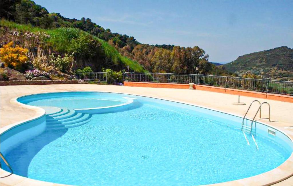 een groot blauw zwembad met een berg op de achtergrond bij Nice Apartment In San Giovanni With Outdoor Swimming Pool in San Giovanni