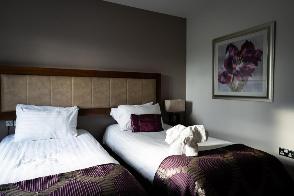 a hotel room with two beds and a picture on the wall at Ballyrobin Hotel in Aldergrove
