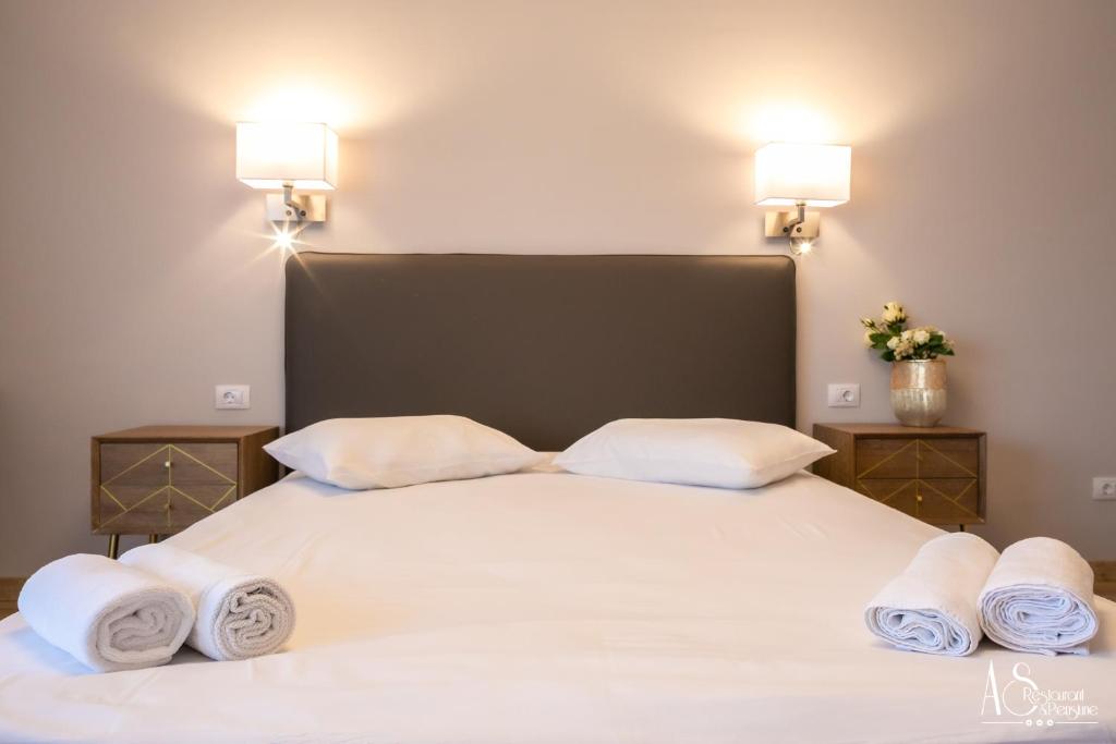 1 dormitorio con 1 cama blanca grande y toallas. en Pensiunea AS, en Floreşti