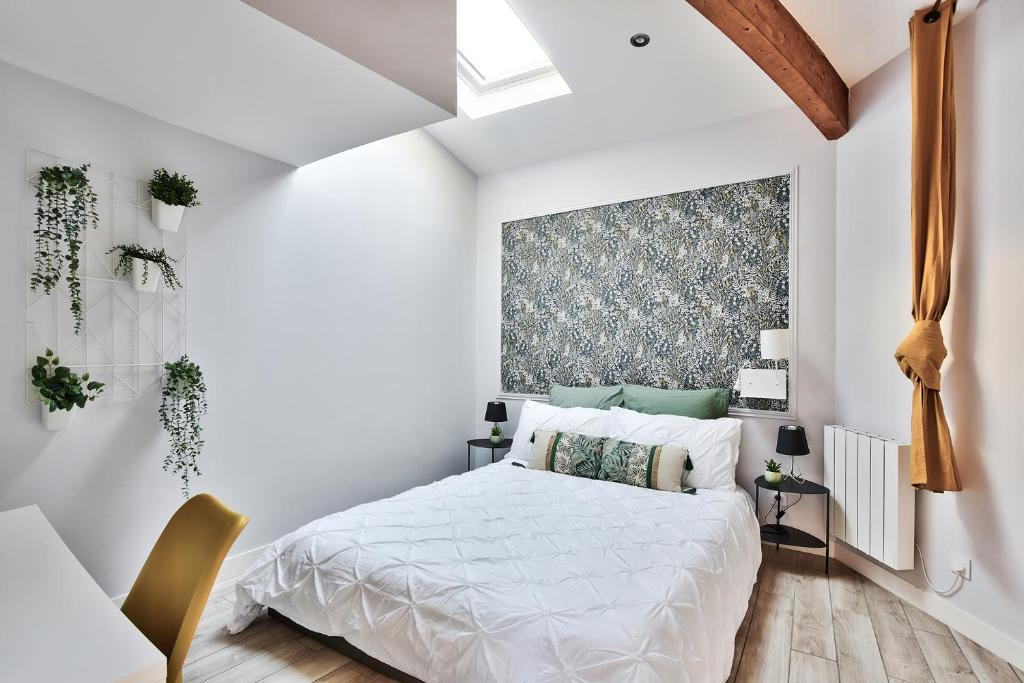 Dormitorio blanco con cama y ventana grande en Appartement L’Élégant - Idéalement Situé, en Écully