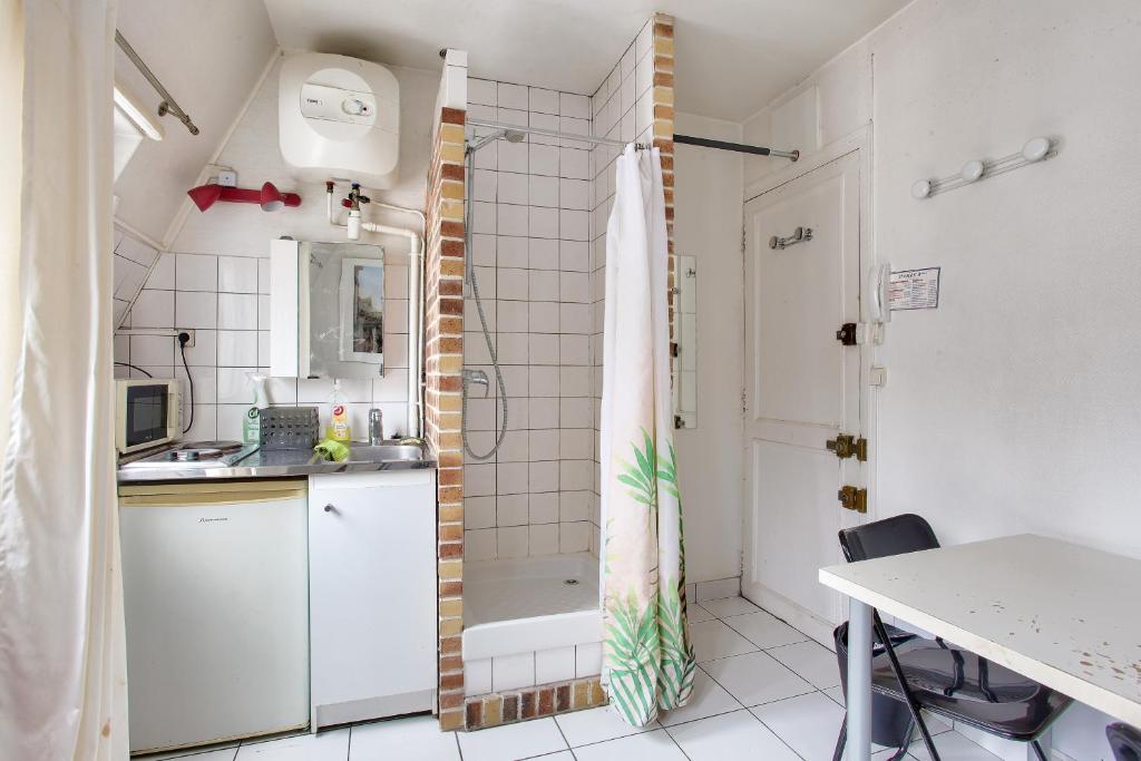 ein kleines Bad mit einer Dusche und einem Waschbecken in der Unterkunft Cosy studio in the 8th arr 4 min from Rome metro in Paris