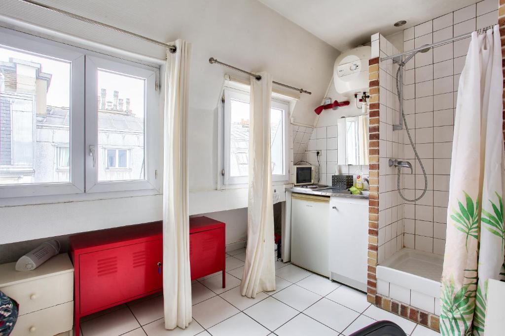 eine kleine Küche mit einem roten Schrank im Bad in der Unterkunft Cosy studio in the 8th arr 4 min from Rome metro in Paris