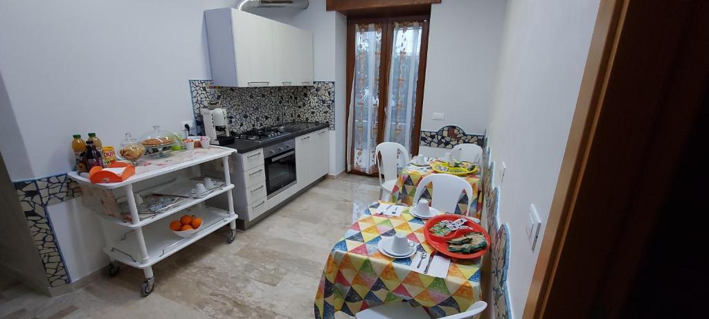 kuchnia ze stołem, krzesłami i kuchenką w obiekcie B&B Le Gorgonie w mieście Tortora