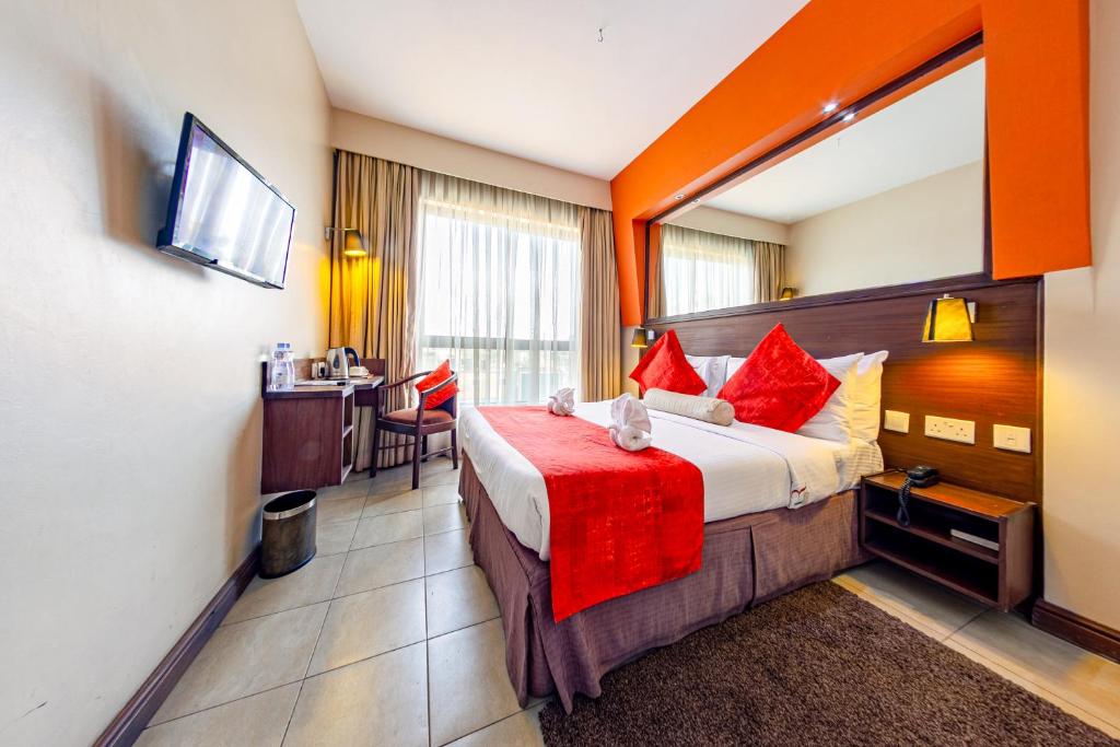 a hotel room with a bed and a table at Hotel Rio in Nairobi