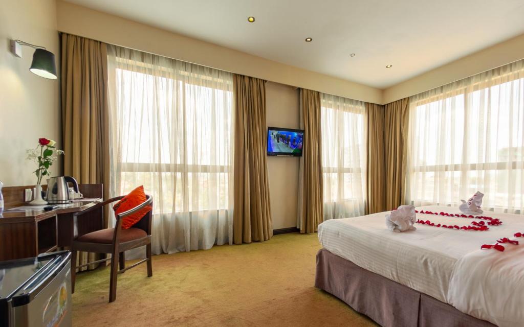 a hotel room with a bed and a desk at Hotel Rio in Nairobi