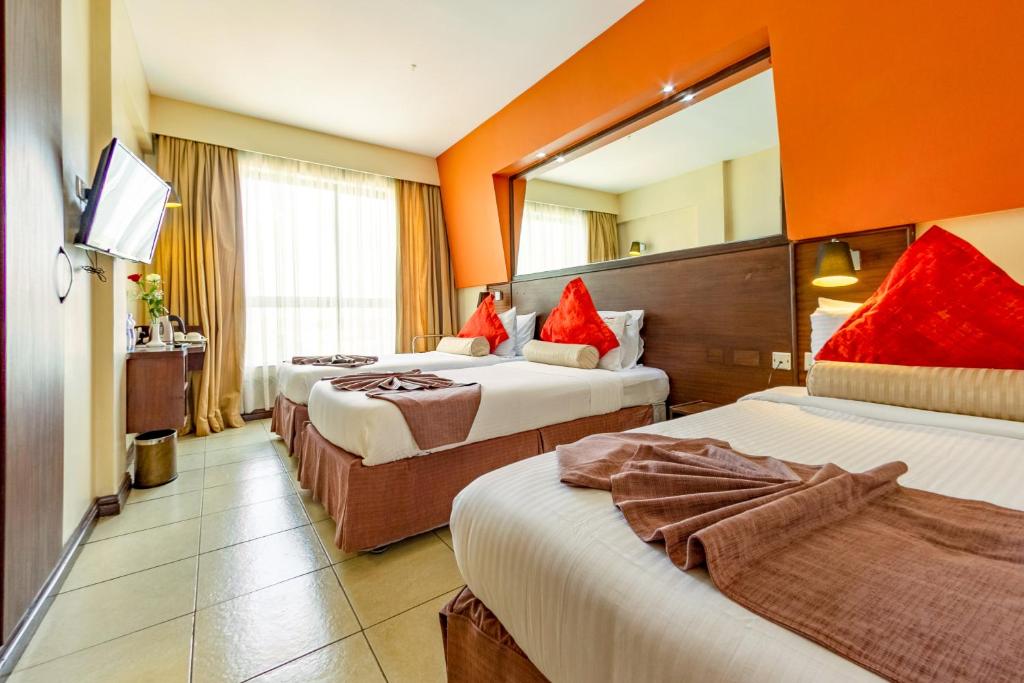 a hotel room with two beds and a mirror at Hotel Rio in Nairobi