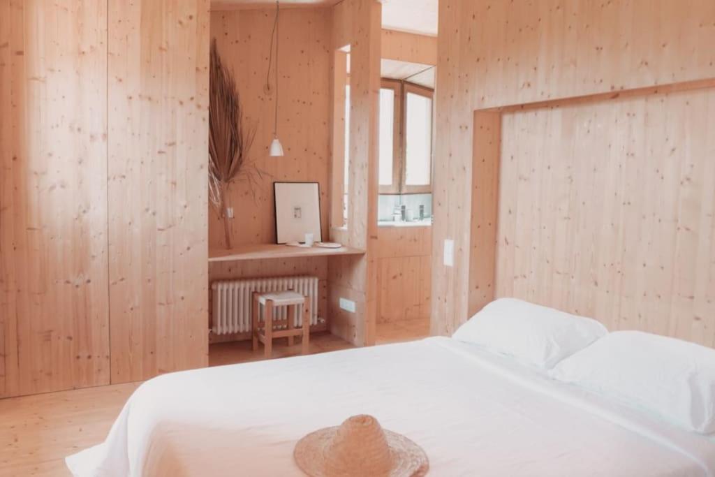 a bedroom with a white bed with a hat on it at El Apartamento in Manacor