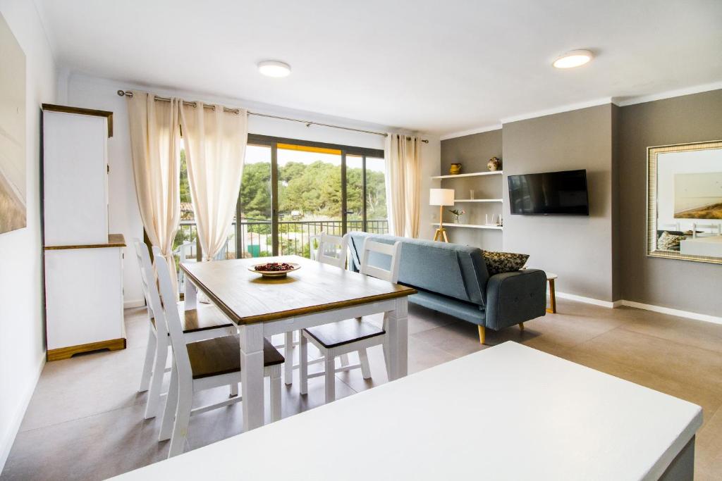 a kitchen and living room with a table and chairs at Apartamento Ponent 1 in Cala Ratjada