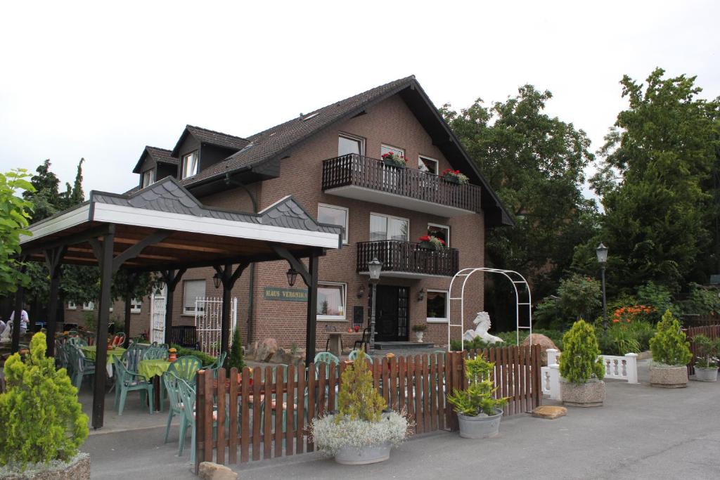 a building with a fence and tables and chairs at Gästehaus Veronika in Altenberge