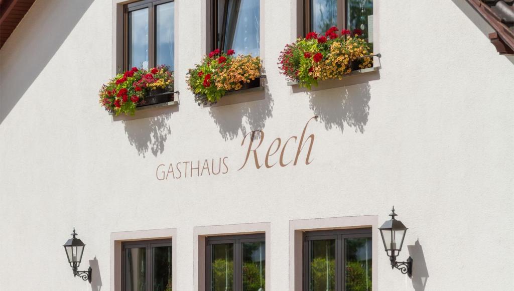 a white building with two windows with flowers on it at Gasthaus Rech in Eppelborn