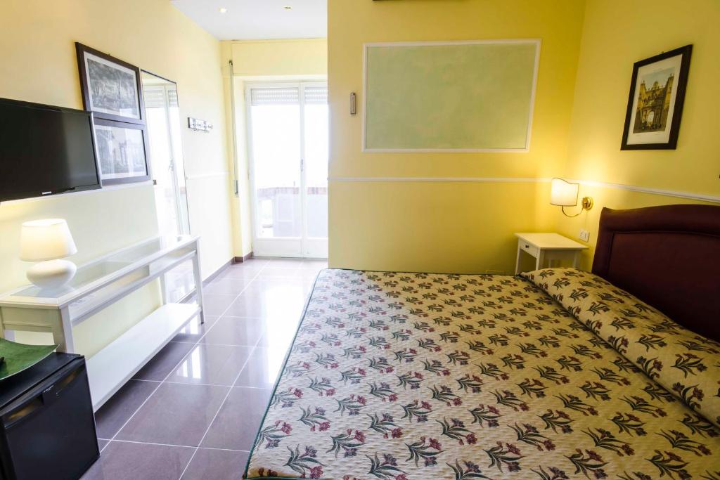 タルクイーニアにあるホテル タルコンテのベッドルーム(ベッド1台、薄型テレビ付)