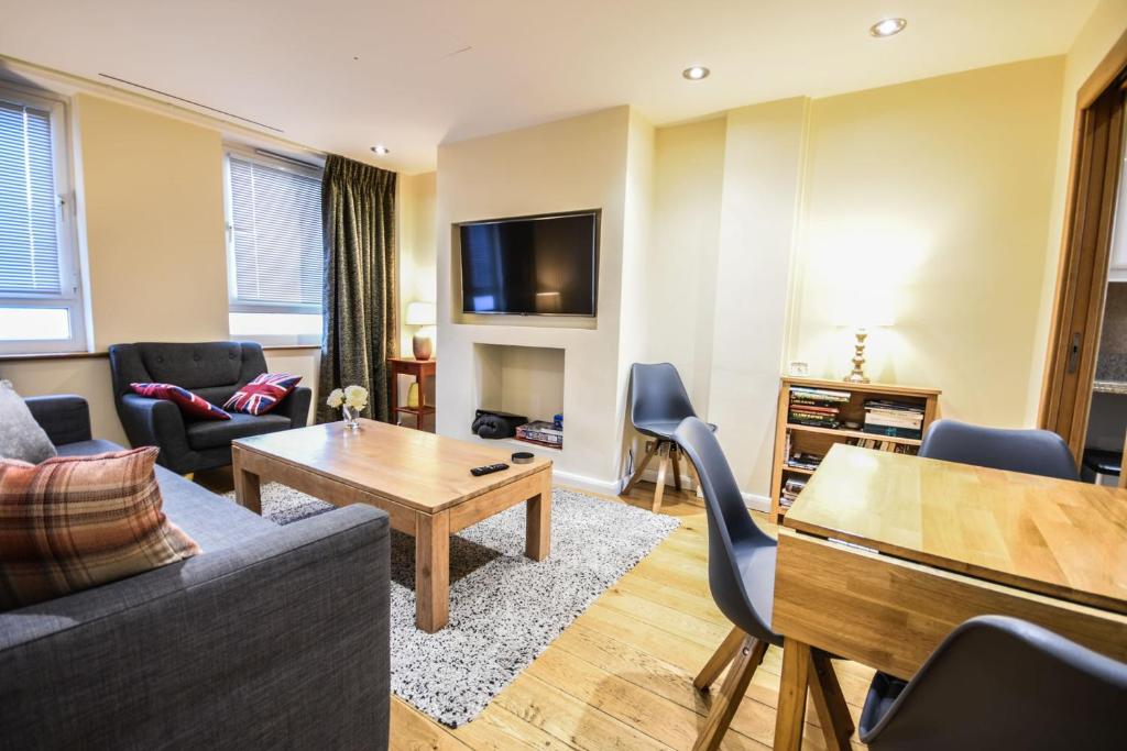 ein Wohnzimmer mit einem Sofa und einem Tisch in der Unterkunft Tower Bridge 2BR apartment for 6 with terrace in London