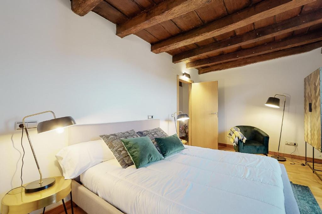 a bedroom with a large white bed with two lamps at Casa Rural Ixurkonea in Arbizu