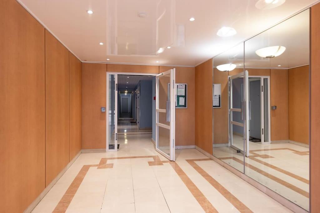 a hallway with glass doors in a building at Charmant T2 proche de Disney in Noisy-le-Grand