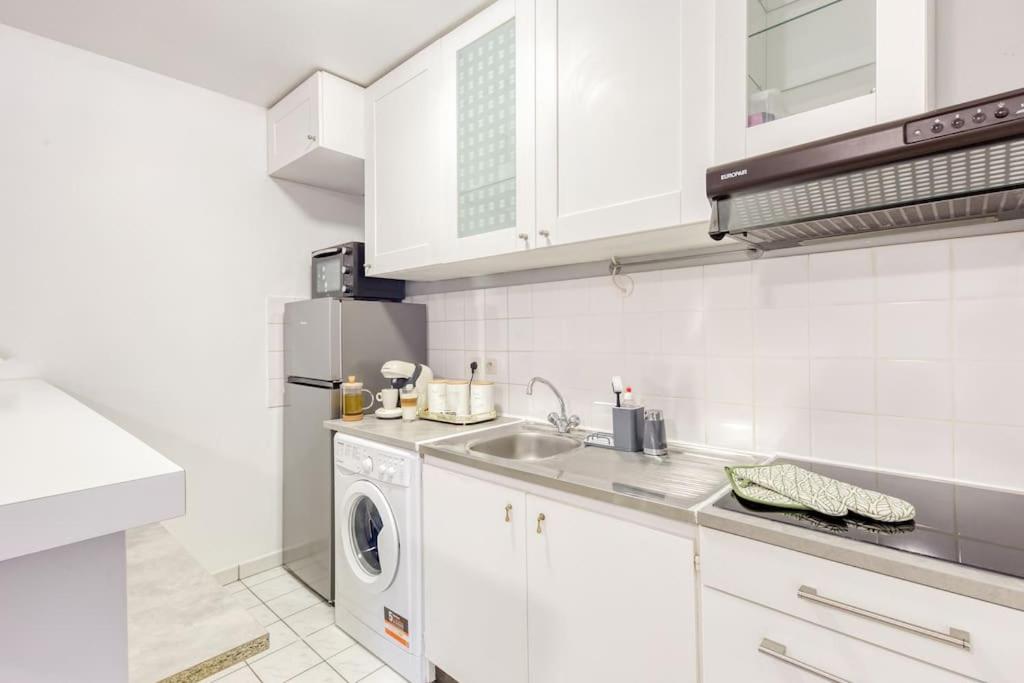 a white kitchen with a sink and a washing machine at Charmant T2 proche de Disney in Noisy-le-Grand
