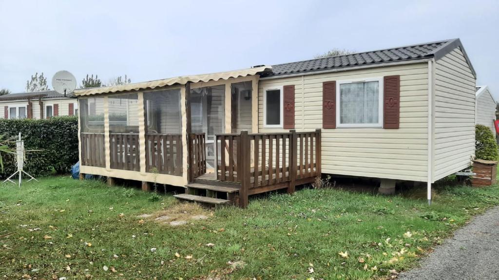 une maison assise dans l'herbe dans l'établissement mobile home la Yole 4 étoiles au calme 6 personnes, à Saint-Jean-de-Monts
