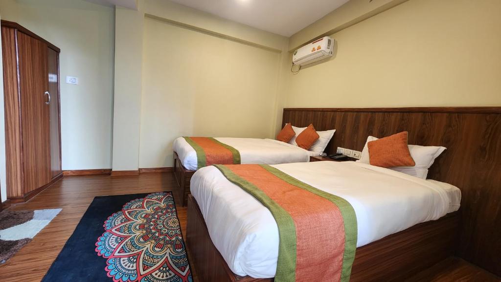 a hotel room with two beds and a window at Kuna Resort in Kathmandu