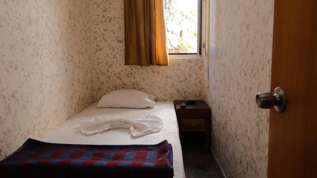 アンタルヤにあるAziz Pansiyon 3のベッドと窓が備わる小さな客室です。