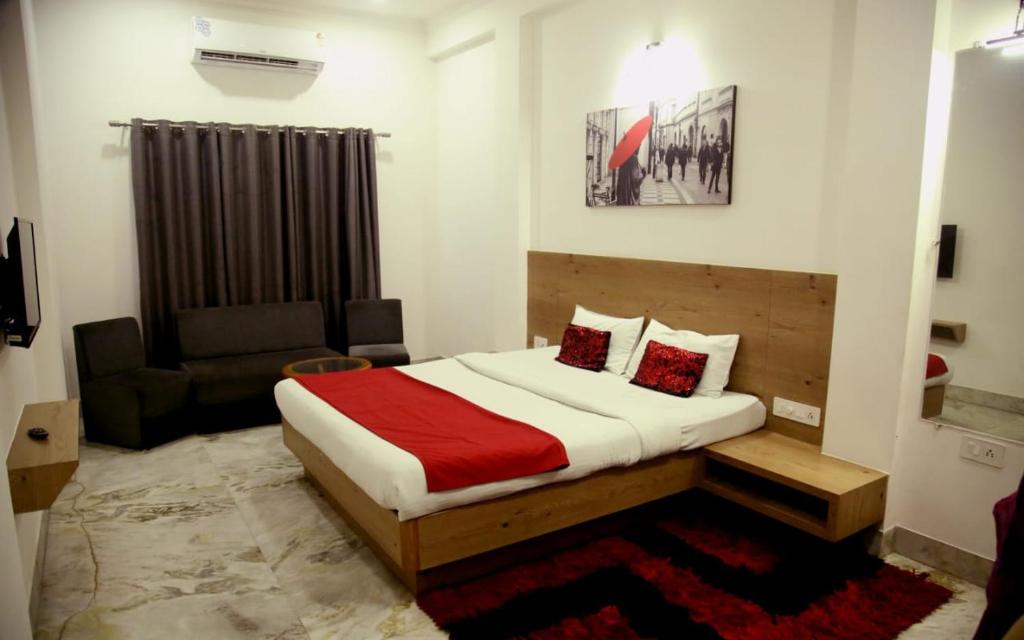 a small bedroom with a bed and a couch at Hotel Nisha Nest, Bhopal in Bhopal