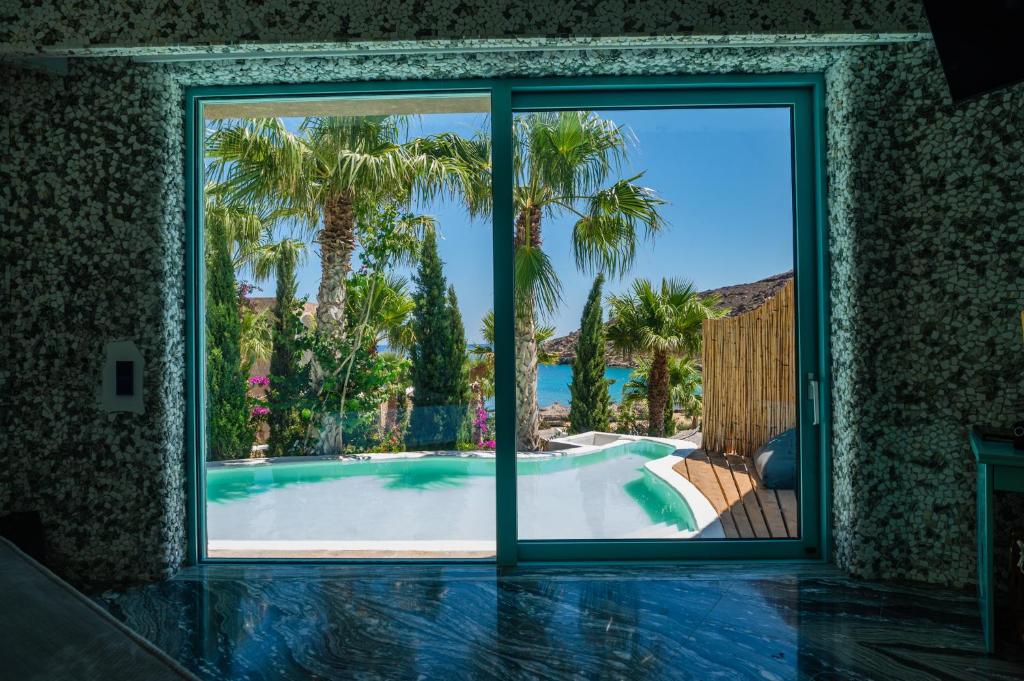 a room with a view of a swimming pool through a window at Calilo in Manganari