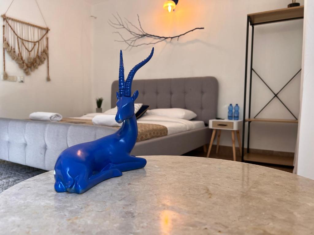 una figurita de dinosaurio azul sentada en una mesa en un dormitorio en Lord of the Dead Sea by CROWN en Neve Zohar