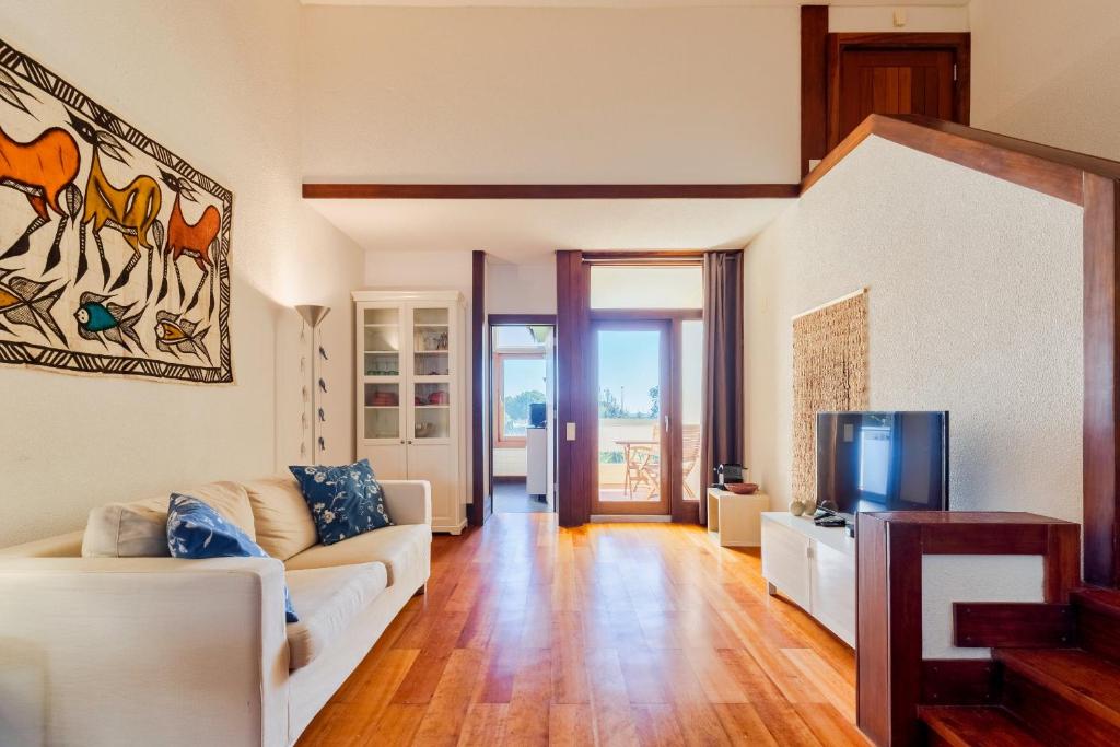 a living room with a couch and a tv at Apartamento Troia in Troia
