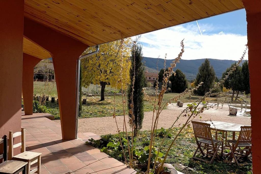 patio con mesa, sillas y vistas en El Telar Arte y Naturaleza, en Prádena