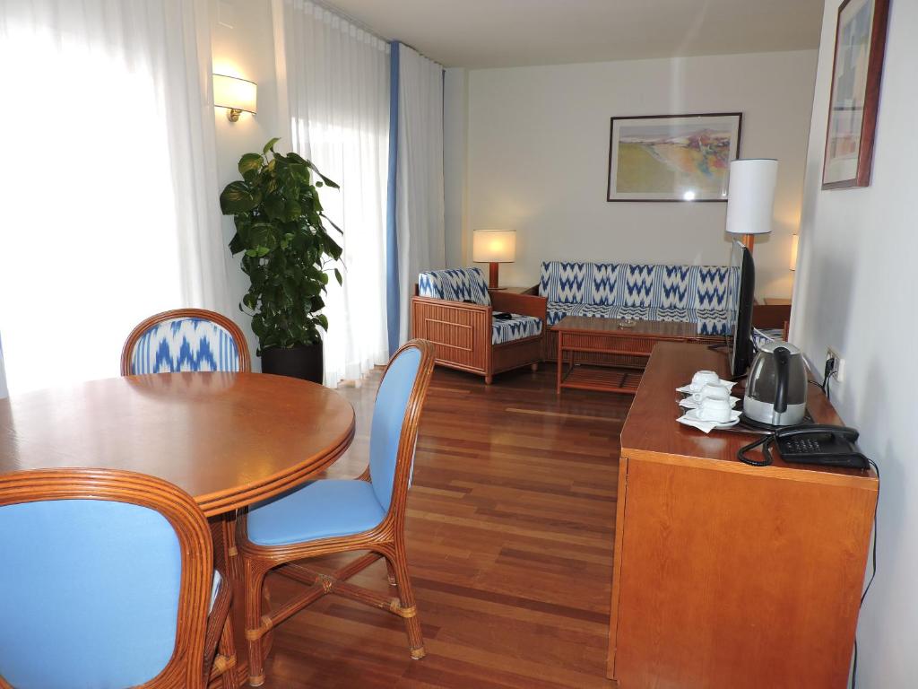 a living room with a table and chairs and a living room at Estival Park Silmar in La Pineda