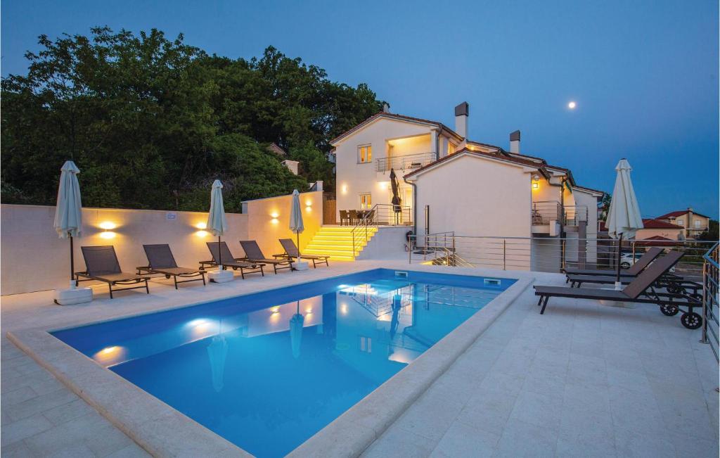 a swimming pool with chairs and a house at Nice Home In Kastav With Wifi in Kastav