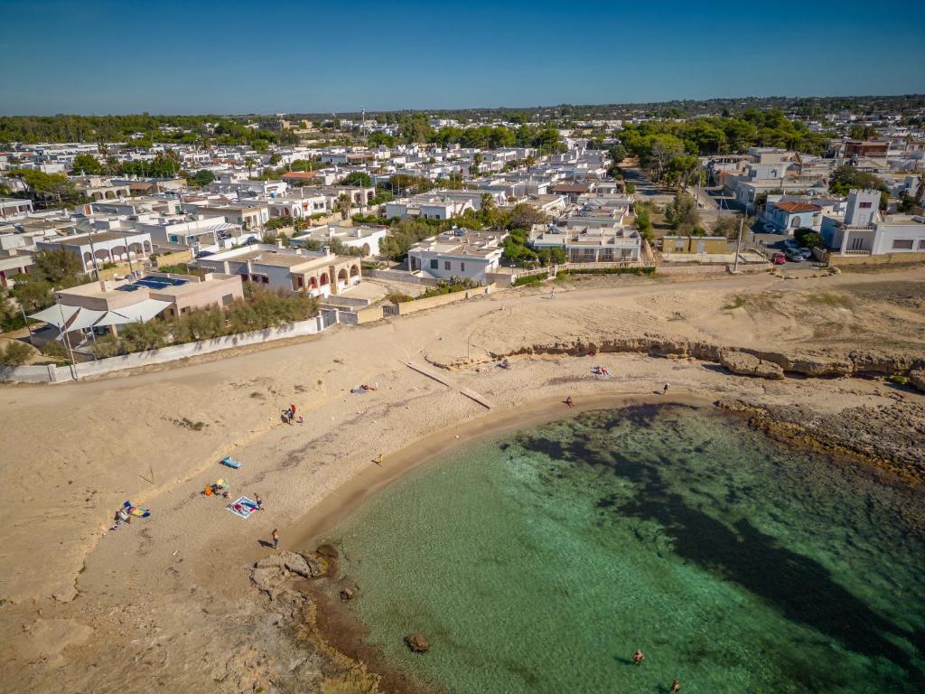 una vista aerea di una spiaggia con persone in acqua di Residence Caletta a Marina di Mancaversa