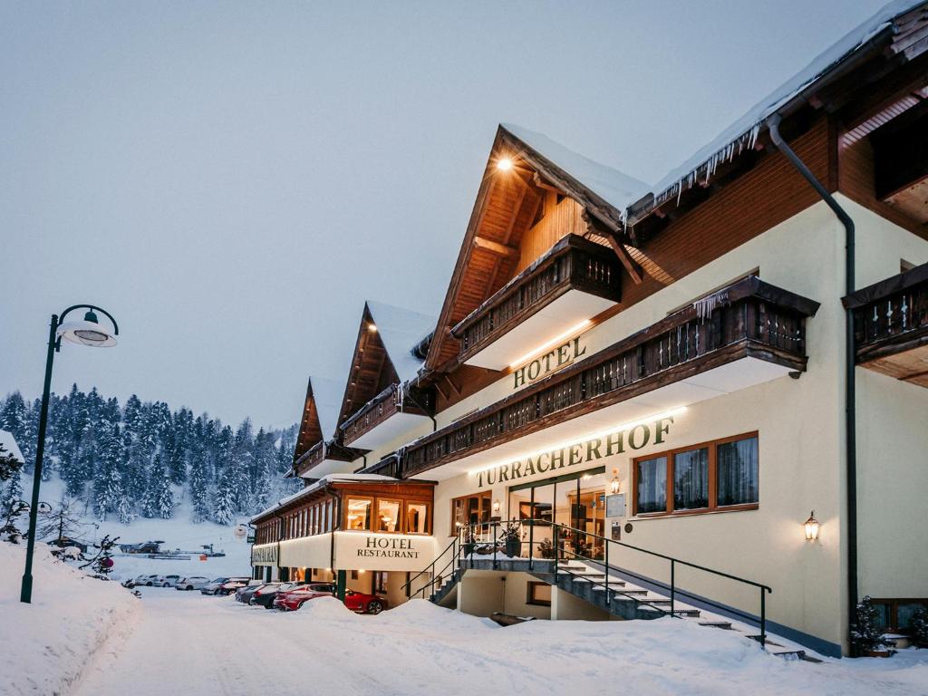 un hotel en invierno con nieve en el suelo en Hotel Turracherhof, en Turracher Höhe