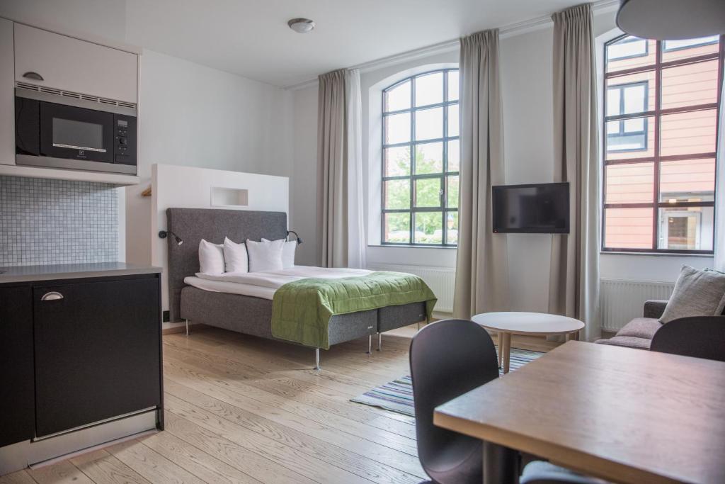 Habitación de hotel con cama y sala de estar. en The More Hotel Lund, en Lund