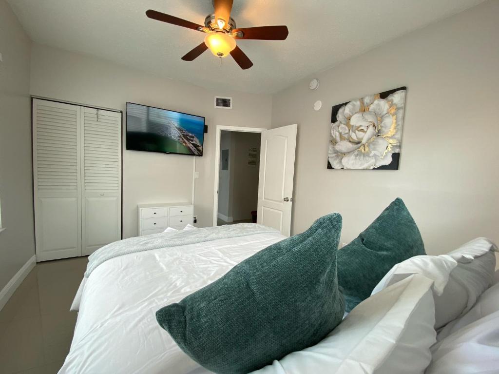 sypialnia z łóżkiem z poduszkami i wentylatorem sufitowym w obiekcie Marlins Park Suites - APT 2 - Gallo Suite w Miami