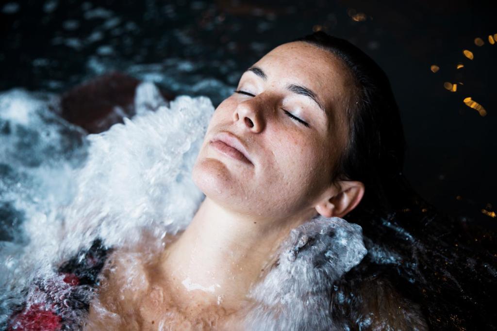 a woman in a bathtub filled with water at Dukley Hotel & Resort in Budva