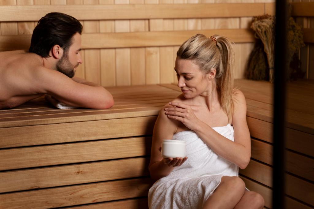 a man and a woman sitting in a sauna at Dukley Hotel & Resort in Budva