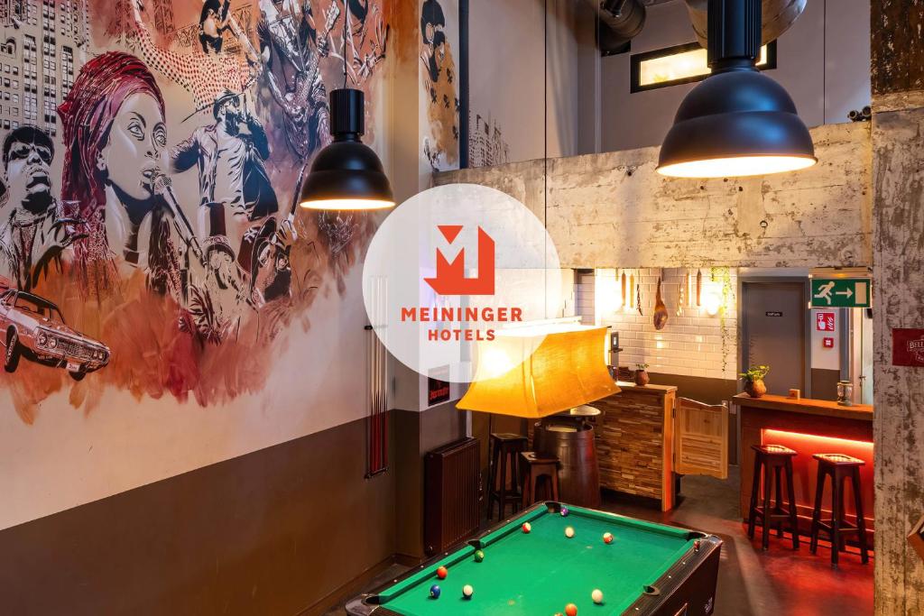 a pool table in a room with a mremember institute sign at MEININGER Hotels Bruxelles City Center in Brussels