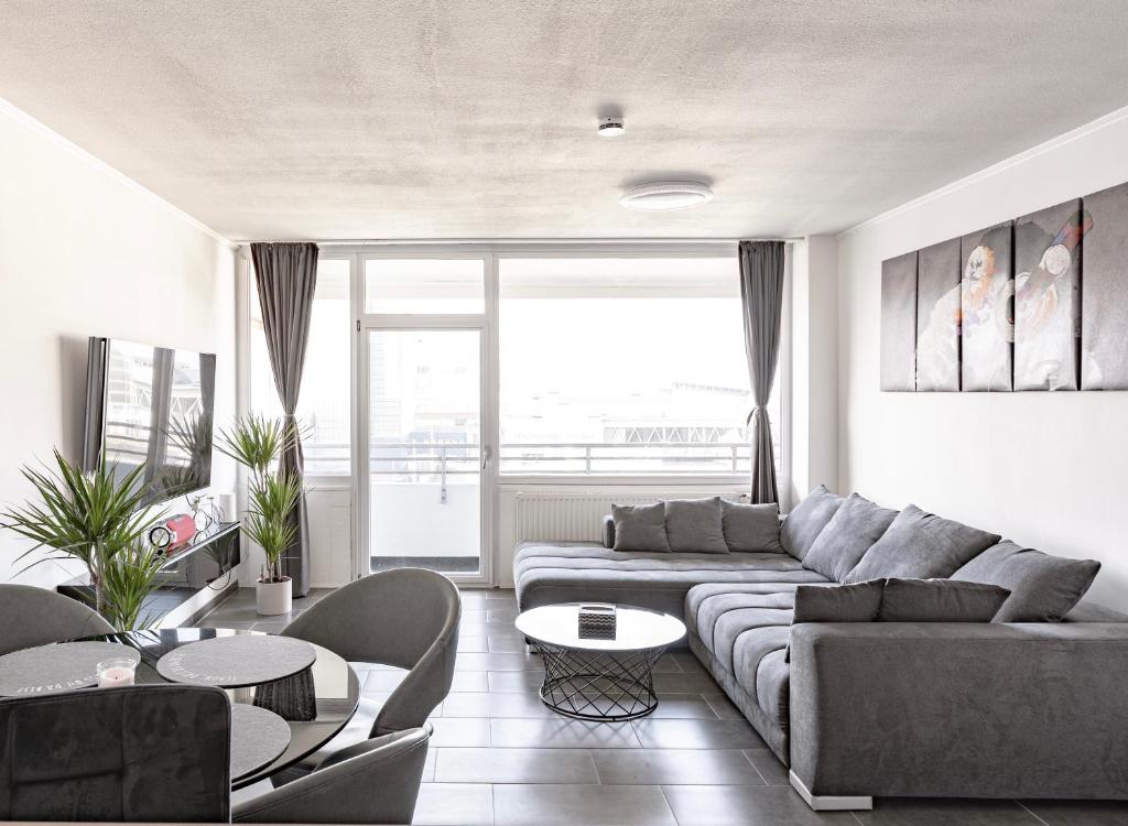 ein Wohnzimmer mit einem Sofa und einem Tisch in der Unterkunft TOP 60qm Eigentumswohnung Neuss/DüsseldorfMesseKÖ in Neuss