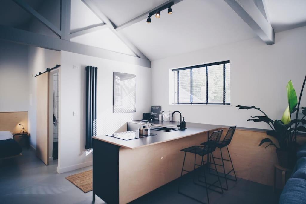a kitchen with a counter and stools in a room at Blackett Street Bunkhouse in Leeds