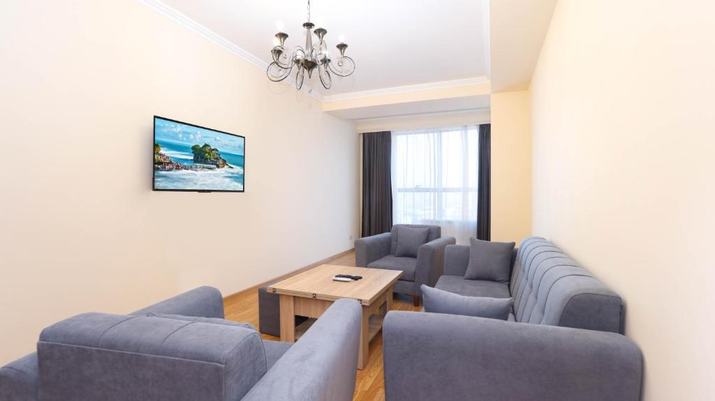Sala de estar con sofás y mesa de centro en Stay Inn Apartments near Dalma Garden Mall, en Ereván