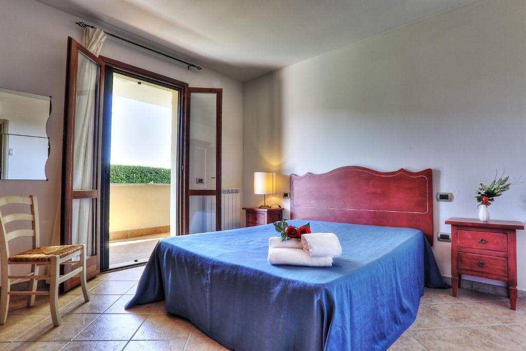 um quarto com uma cama com uma colcha azul e uma janela em I fiori di Alberese em Alberese